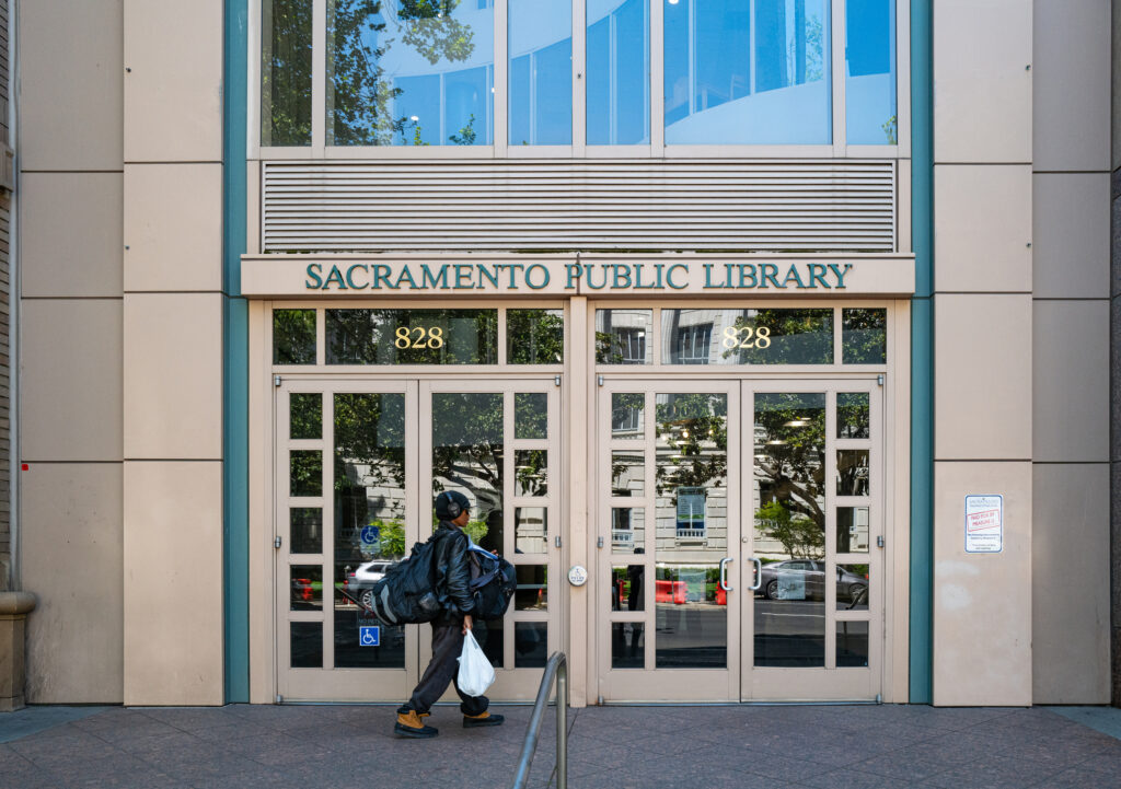 Sacramento, CA, U.S.A. - April 9, 2025: A woman enters the front of the Central Library Branch in downtown. The Trump administration has taken significant steps to reduce support for libraries.